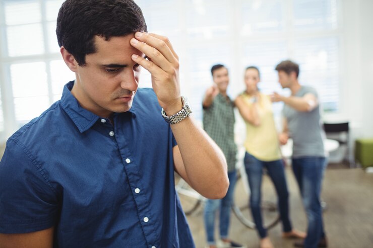 A group of people making fun of a distressed man