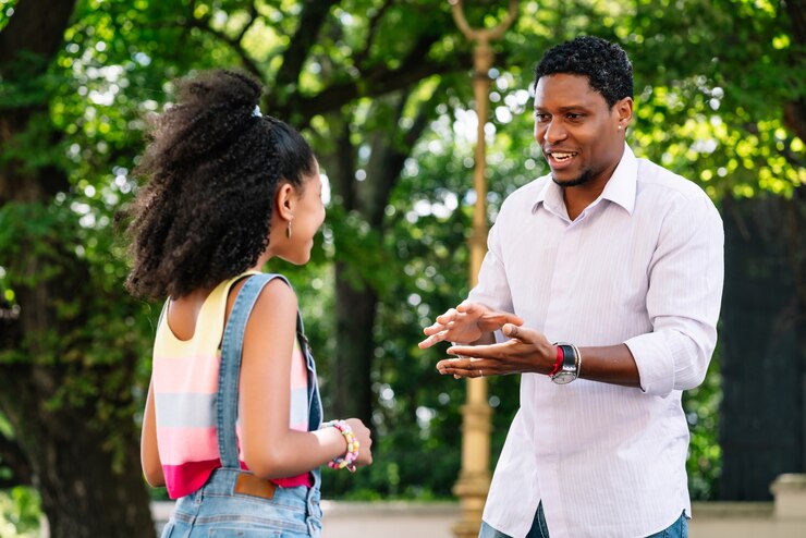 a father talking to his daughter at a park