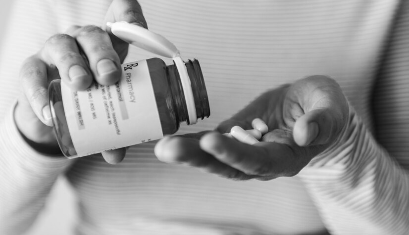 a lady takes pills from a bottle