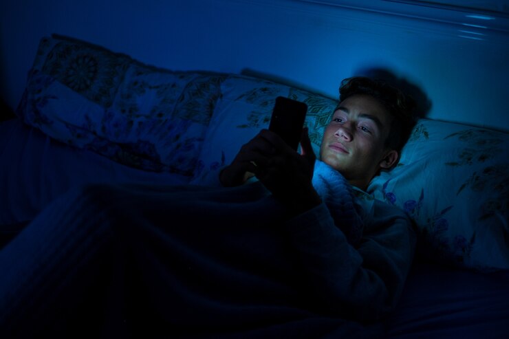 teenager using their phone at night