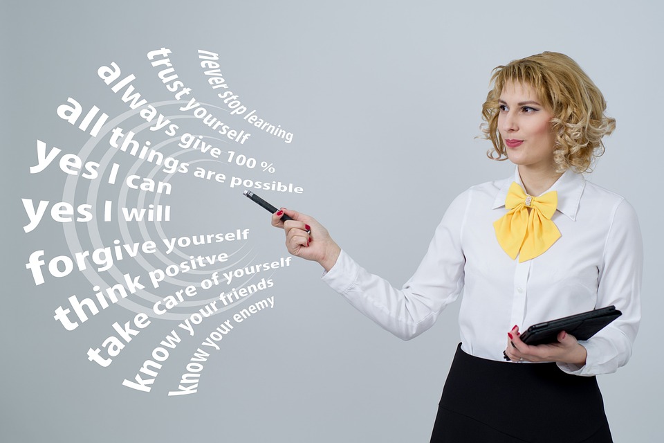 A lady pointing to a picture with motivational messsages