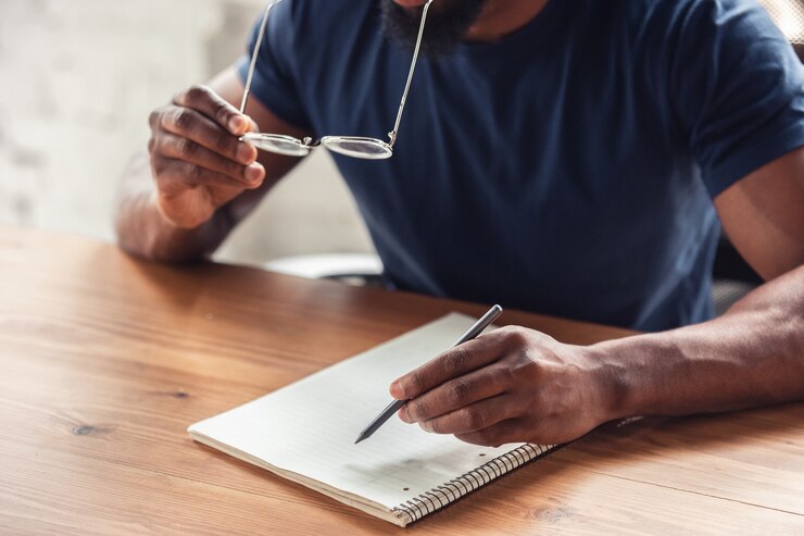 A man writing something in his notebook