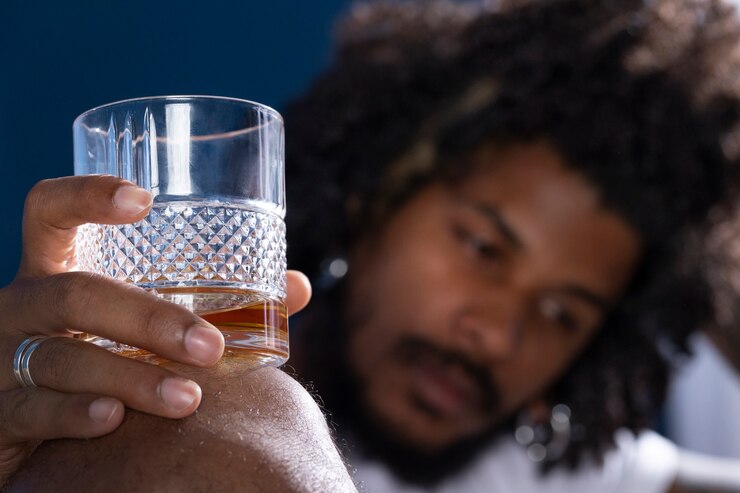 a man holding a glass of alcohol