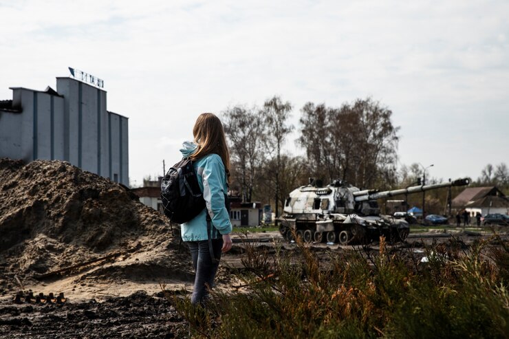 a teenage child standing a few meters away from a fire support vehicle