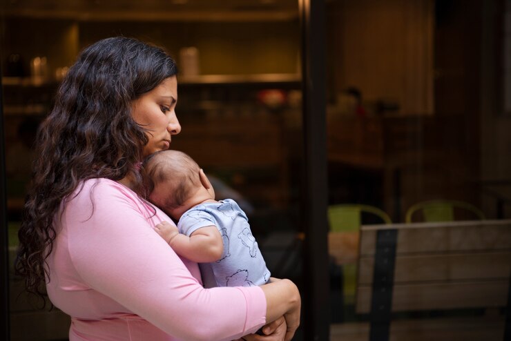 mother looks sad while holding her baby