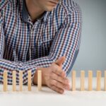 a man uses his hand and wooden blocks to illustrate boundaries