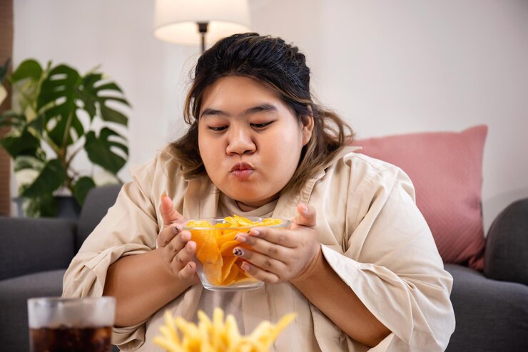 asian woman holding a large bowl of french fries