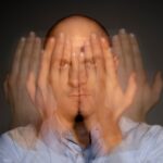 portrait of man seeing multiple pictures of his hand