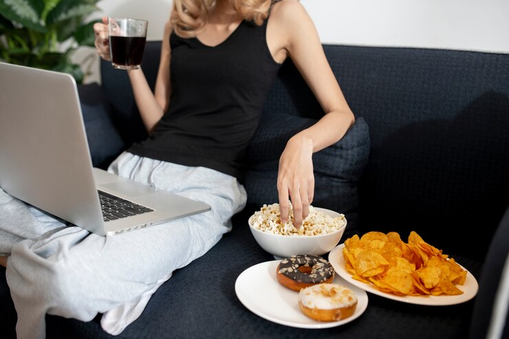 woman with three different plates of food for donuts, crisps and popcorns