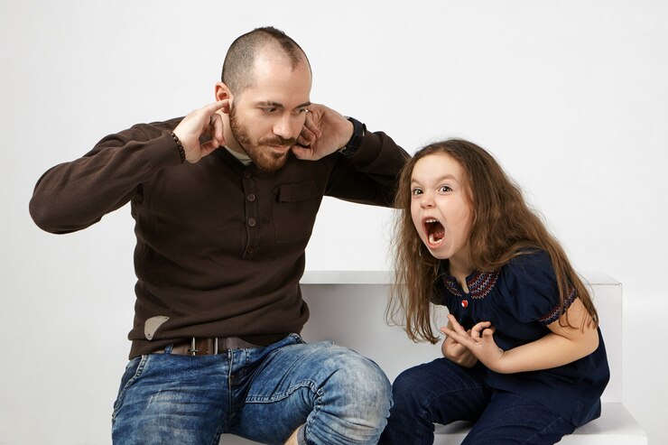 angry child loses her temper and starts screaming at the dad